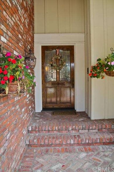 Brick entry walk and a leaded glass front door.