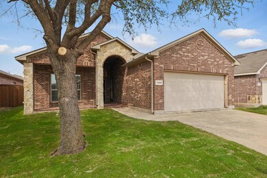 Ranch-style home with brick siding, driveway, a ga