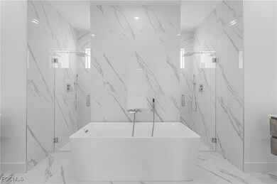Bathroom featuring a freestanding bath, a marble f