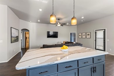 Kitchen with arched walkways, blue cabinets, dark 