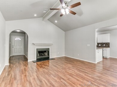 Tall ceilings and a fireplace accent the living ro
