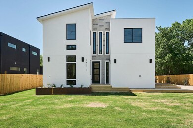 Rear view of house featuring stucco siding, fence