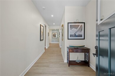 Hallway with light LVP floors and recessed lightin