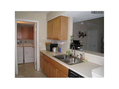 Kitchen with SS sink and breakfast bar. Through th