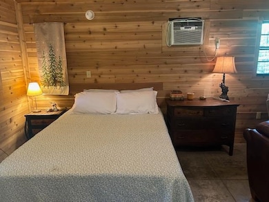Bedroom featuring a wall mounted air conditioner a