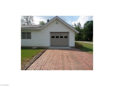 Brick driveway leads to attached garage.