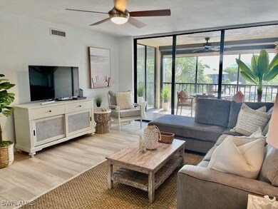 Living area with ceiling fan, light wood-type flooring, a wealth of natural light, and expansive windows