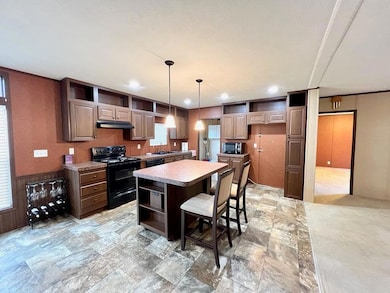 Kitchen with black electric range, open shelves, 