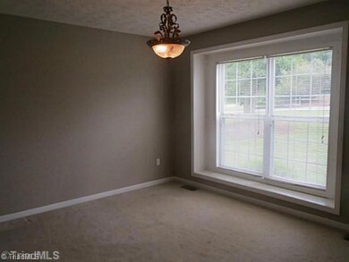 Dining Room. The dining room features large windows providing a view of the front yard.