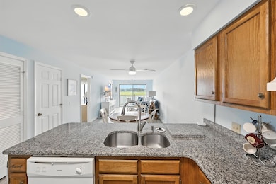 Kitchen featuring dishwasher, a peninsula, brown cabinets, and a ceiling fan