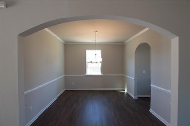 Empty room with arched walkways, dark wood-style f