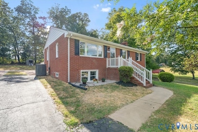 Ranch-style home featuring brick siding, a chimney, asphalt driveway, and a front lawn