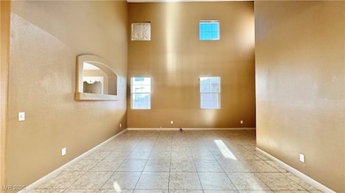 Tiled empty room featuring baseboards and a toweri
