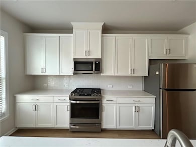 Kitchen featuring decorative backsplash, light cou