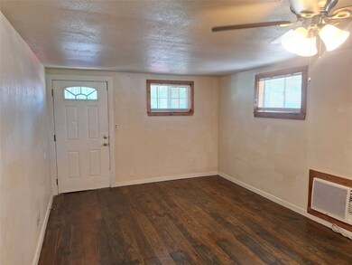 Entrance foyer featuring a textured ceiling, dark wood-style flooring, and ceiling fan