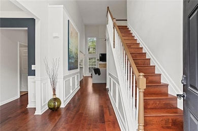 Entryway featuring double height ceiling, a wainsc