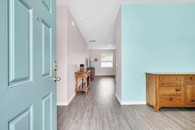 Foyer entrance with light wood-style flooring and baseboards