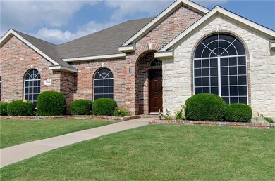 Beautiful brick landscape planters in front and solar screens on windows.