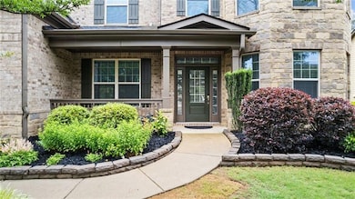 Entrance to property featuring a porch and brick siding
