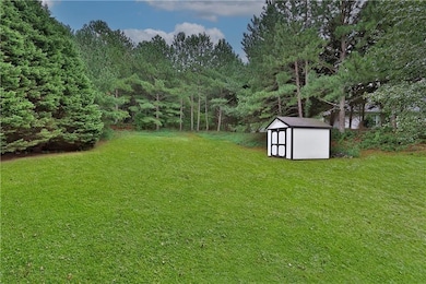 View of grassy yard featuring a storage unit