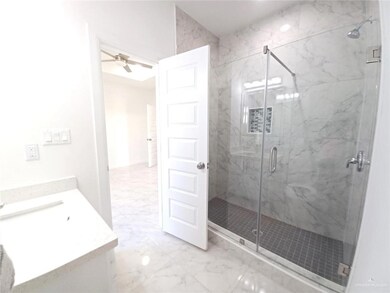 Full bathroom featuring vanity, a marble finish shower, marble finish floor, and a ceiling fan