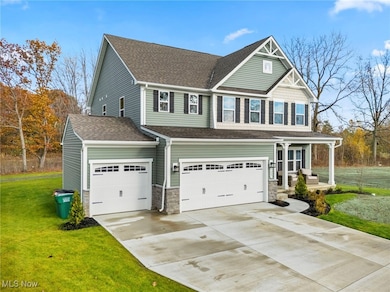 Craftsman-style house featuring a front yard, a shingled roof, concrete driveway, and a porch