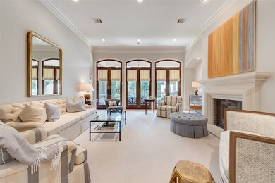 [Living Room 
In the living room, three sets of French doors overlook the sheltered patio and backyard. Note stone fireplace at right.