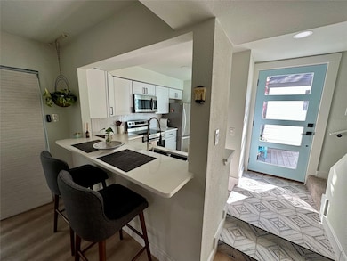 Kitchen featuring white cabinets, appliances with