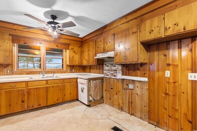 Kitchen featuring under cabinet range hood, a sink