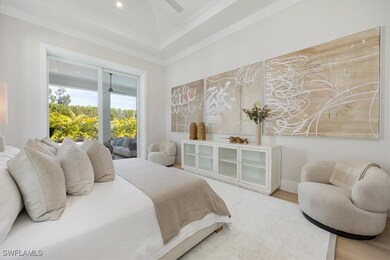 The primary bedroom overlooks the pool deck and fu