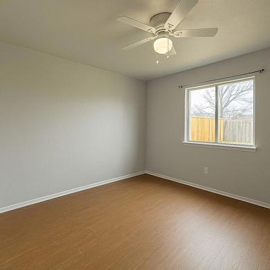 Empty room with ceiling fan and dark wood finishe