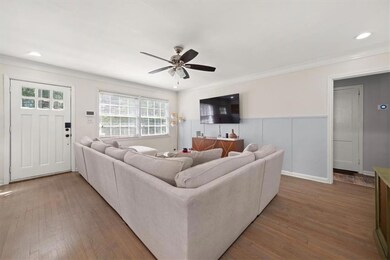 Living room with a ceiling fan, plenty of natural light, crown molding, wood finished floors, and recessed lighting