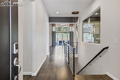 Corridor featuring an upstairs landing, a chandelier, and wood finished floors