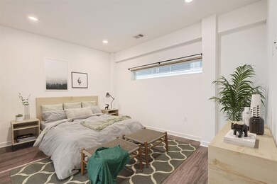 Bedroom featuring dark wood-style flooring, reces