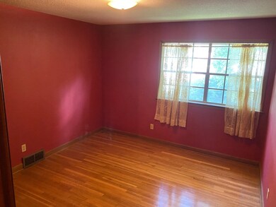 Spare room with a textured ceiling and hardwood / 