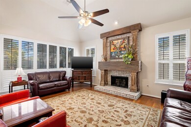Alternate view of the family room with ceiling fan and windows galore with plantation shutters for plenty of natural light.