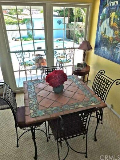 Dining area off living room, pool in background.