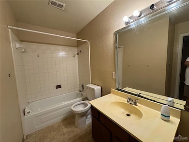 Bathroom featuring visible vents, toilet, shower / tub combination, a textured wall, and tile patterned floors