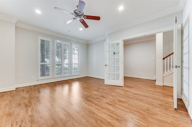 Unfurnished room featuring stairway, ceiling fan, light wood-type flooring, crown molding, and recessed lighting