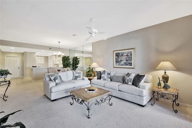 Living room featuring a chandelier, ceiling fan, carpet, and recessed lighting