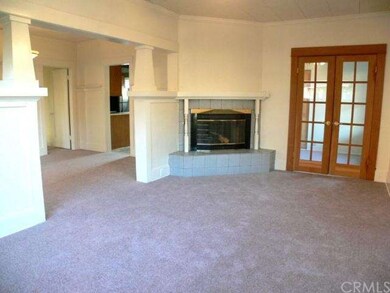 Living room with hardwood floors under carpeting. 