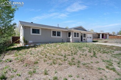 Rear view of house with stucco siding, a garage, a