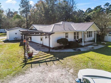 Single story home featuring a metal roof, a carport, and a porch