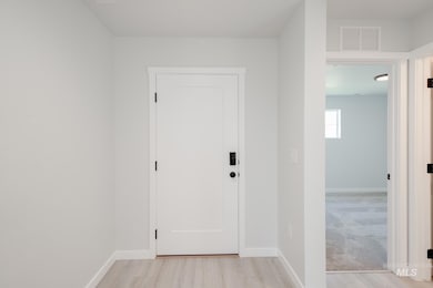 Corridor featuring baseboards and light wood-style flooring