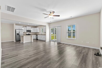 Unfurnished living room with ceiling fan and hardw