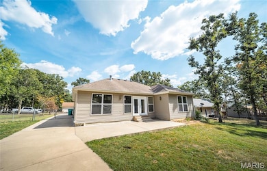 Single story home with a patio area and concrete driveway
