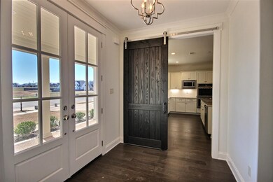Gorgeous front entry with barn door leading to kit