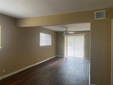 Unfurnished room with a textured ceiling, dark wood-type flooring, and a ceiling fan