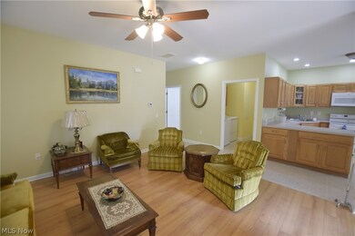 Living room featuring light hardwood / wood-style floors, ceiling fan, and washer / clothes dryer