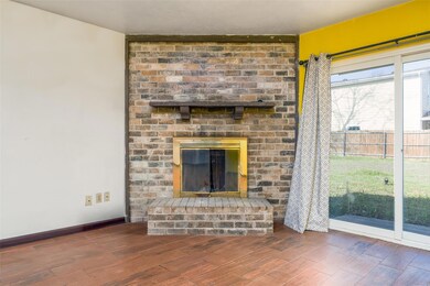Unfurnished living room with a brick fireplace, ba